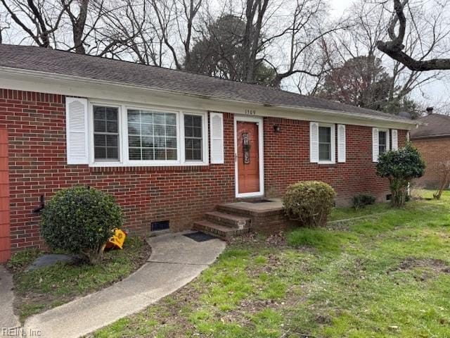 view of front of house featuring brick siding, crawl space, a front yard, and a shingled roof