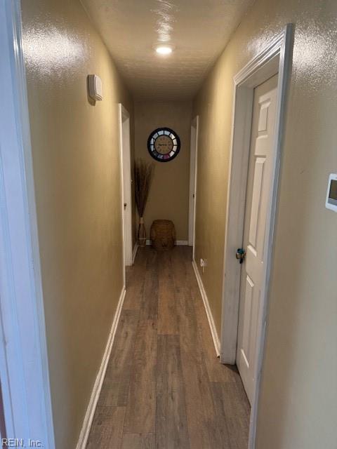 hall featuring baseboards and wood finished floors