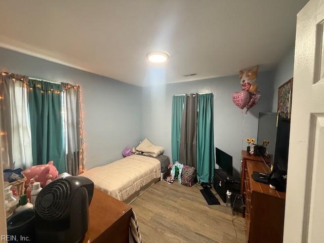 bedroom featuring visible vents and wood finished floors