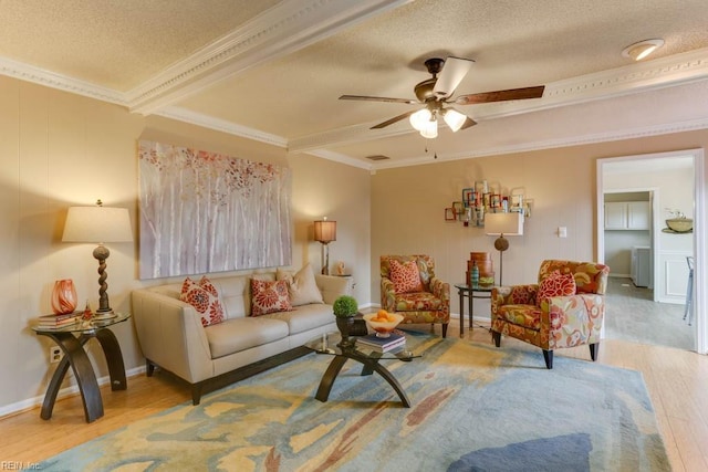 living area with light wood-type flooring, crown molding, and a textured ceiling