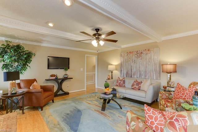 living area with a ceiling fan, crown molding, baseboards, and wood finished floors