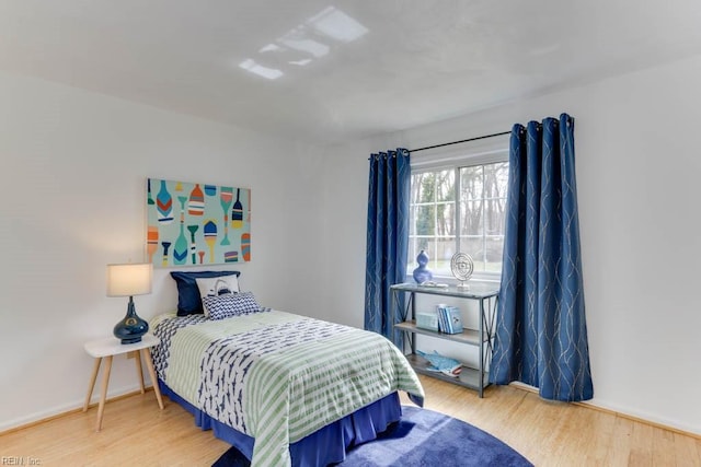 bedroom featuring baseboards and wood finished floors