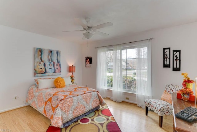 bedroom with baseboards, a ceiling fan, and wood finished floors