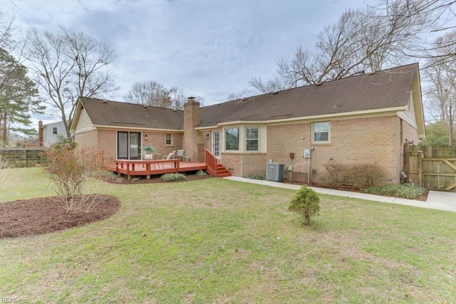 rear view of property with a chimney, fence, and brick siding