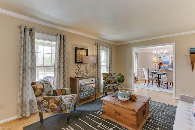 living room with a chandelier, baseboards, wood finished floors, and crown molding