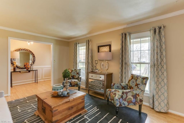 living area with crown molding, baseboards, and wood finished floors