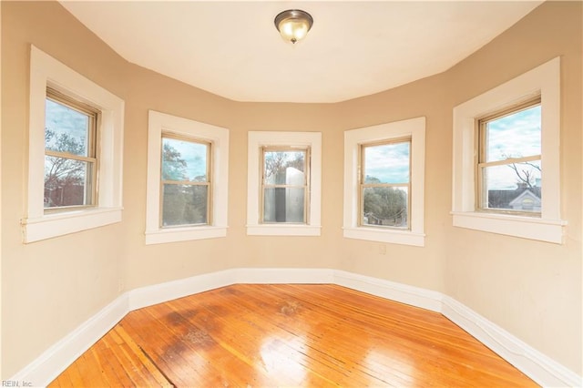 unfurnished room with wood-type flooring and baseboards