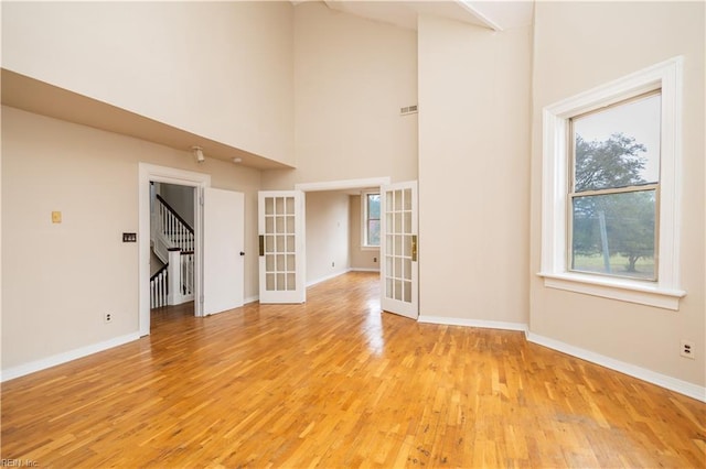 interior space featuring french doors, light wood-style flooring, and baseboards