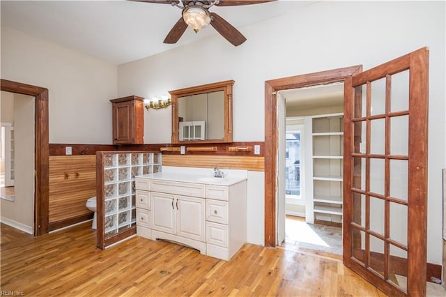 bathroom with toilet, ceiling fan, wood finished floors, and vanity