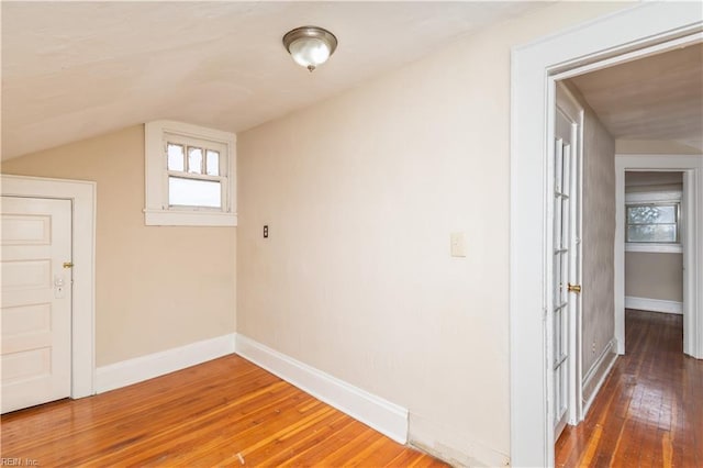 bonus room featuring vaulted ceiling, baseboards, and hardwood / wood-style flooring