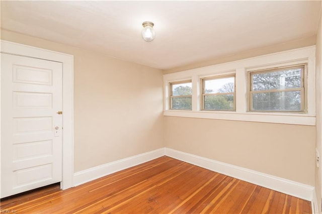 unfurnished room with hardwood / wood-style flooring and baseboards