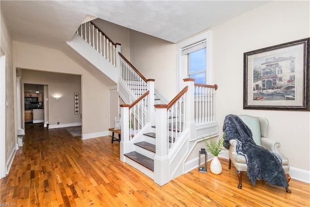 staircase with wood-type flooring and baseboards