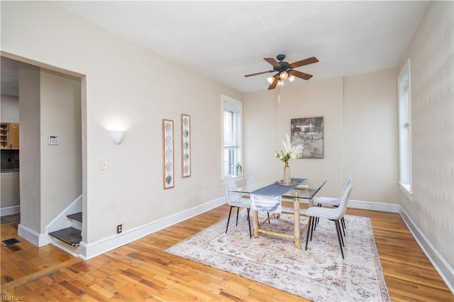 dining area with ceiling fan, stairway, wood finished floors, and baseboards