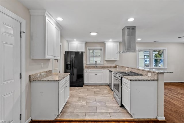 kitchen with light stone counters, a peninsula, island exhaust hood, stainless steel appliances, and white cabinetry