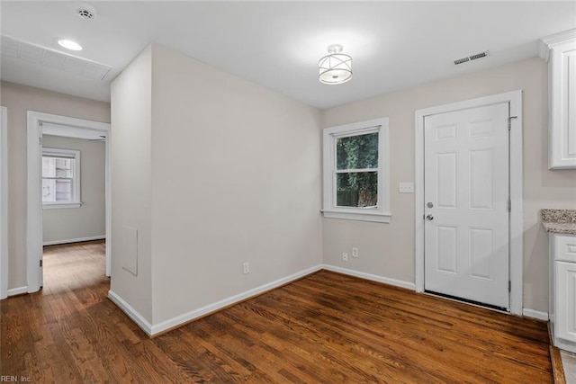 entryway with visible vents, baseboards, and wood finished floors