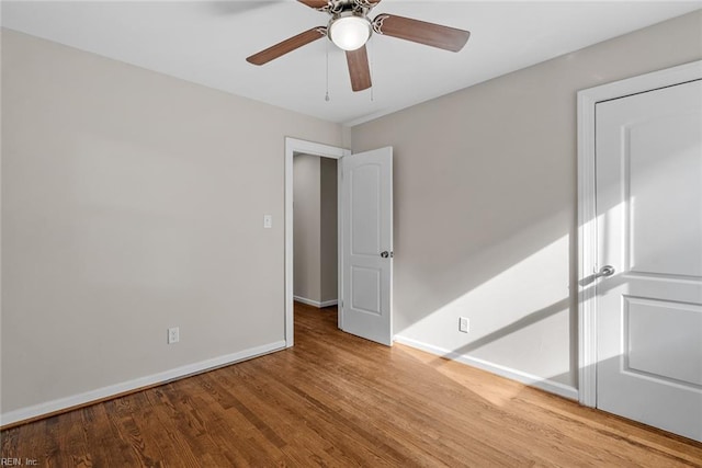 unfurnished bedroom with wood finished floors, a ceiling fan, and baseboards