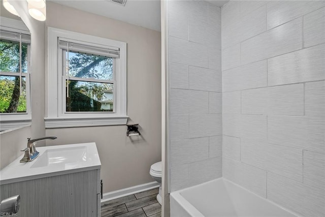 full bathroom with a healthy amount of sunlight, baseboards, toilet, and wood finish floors