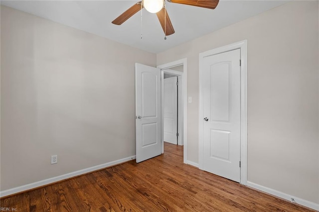 unfurnished bedroom featuring wood finished floors, a ceiling fan, and baseboards