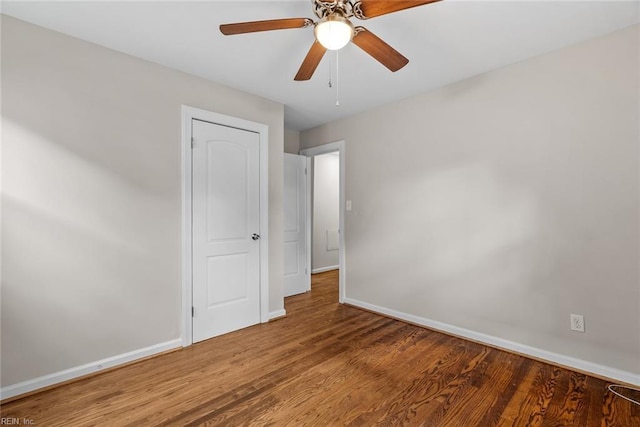 unfurnished bedroom with ceiling fan, baseboards, and wood finished floors