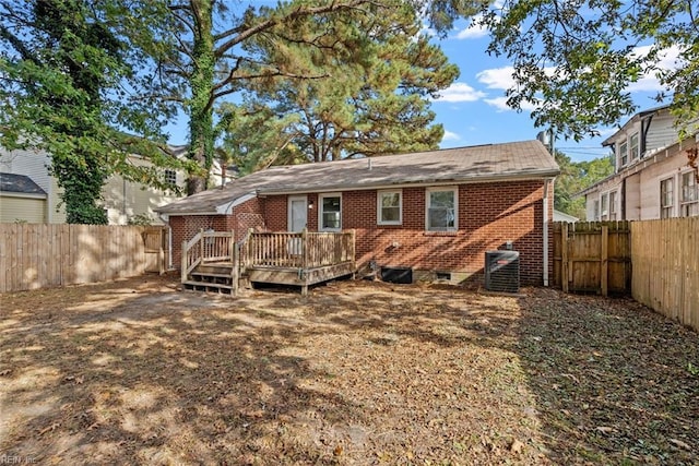 back of house featuring brick siding, a fenced backyard, a wooden deck, and central air condition unit