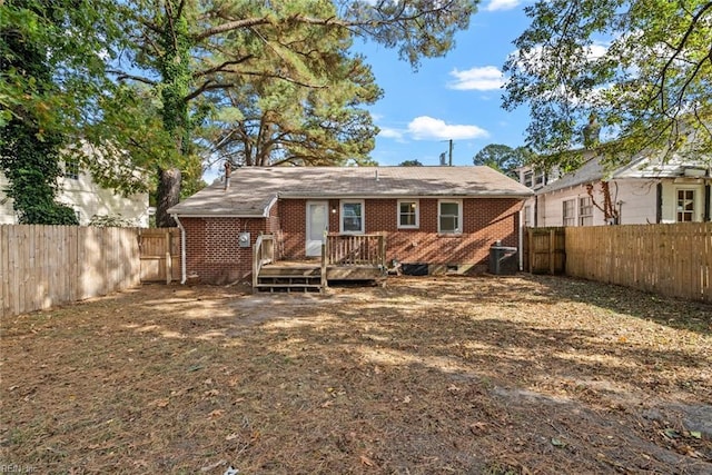 back of house with brick siding, cooling unit, a fenced backyard, and a wooden deck