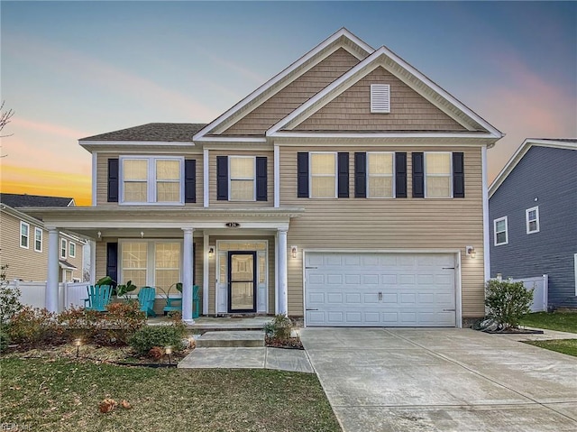 view of front of property with a porch, driveway, and a garage