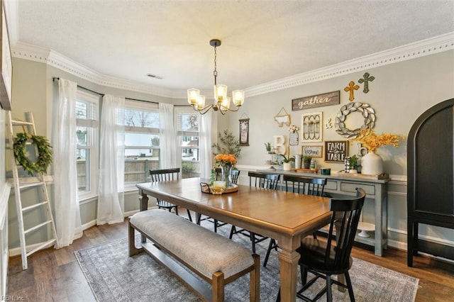 dining room with ornamental molding, arched walkways, a notable chandelier, and wood finished floors