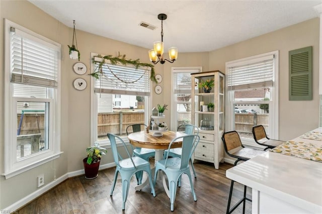 dining area with visible vents, dark wood finished floors, baseboards, and an inviting chandelier