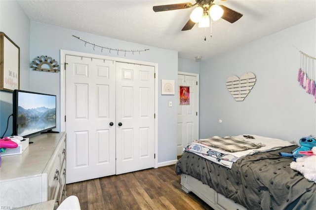 bedroom with dark wood-type flooring, a closet, a textured ceiling, and a ceiling fan