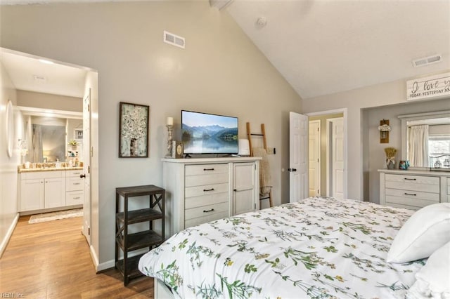 bedroom with visible vents, vaulted ceiling, baseboards, and wood finished floors