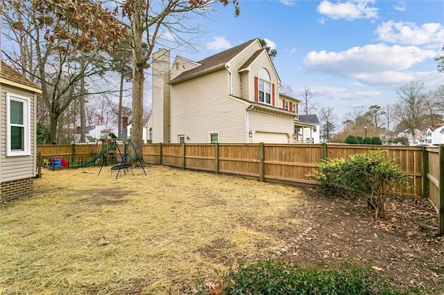 view of yard with a fenced backyard and a playground