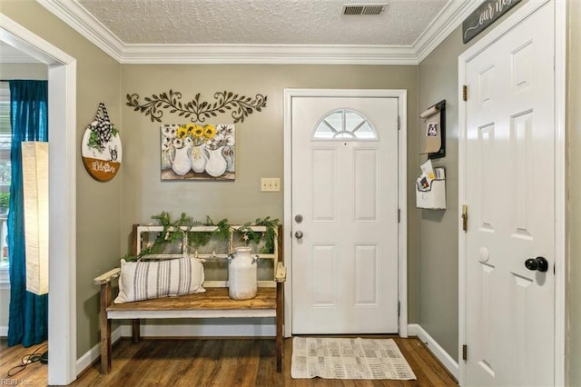 foyer with ornamental molding, visible vents, a textured ceiling, and wood finished floors