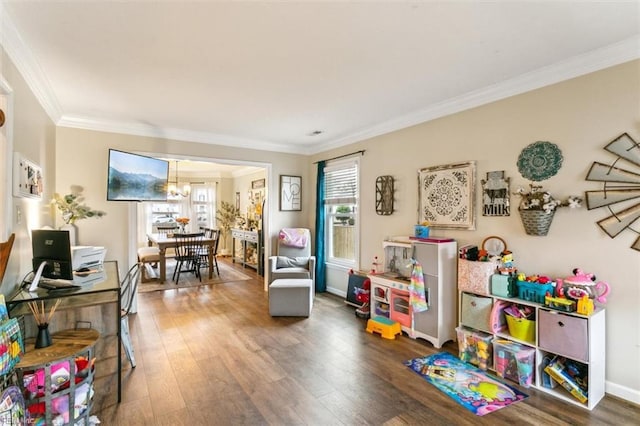 rec room featuring an inviting chandelier, crown molding, baseboards, and wood finished floors