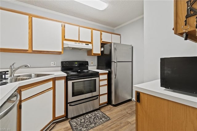 kitchen featuring appliances with stainless steel finishes, light wood-type flooring, a sink, and under cabinet range hood