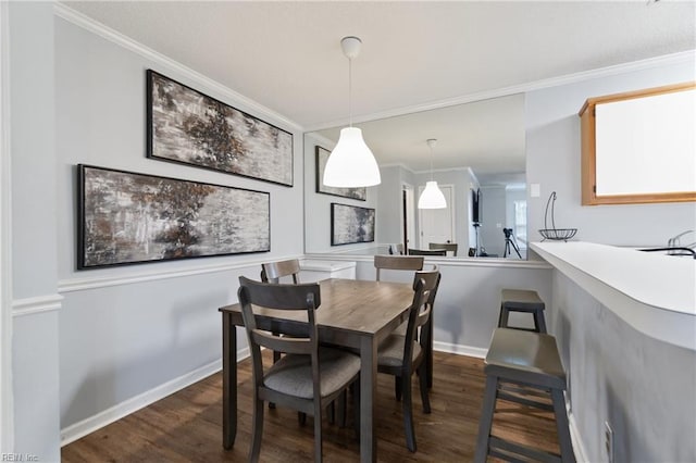 dining area featuring dark wood-style flooring, crown molding, and baseboards