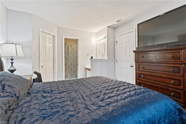 bedroom with a textured ceiling and ensuite bathroom