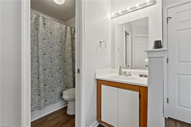 full bathroom with toilet, a shower with shower curtain, wood finished floors, and vanity