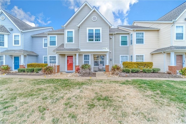 townhome / multi-family property featuring a front lawn