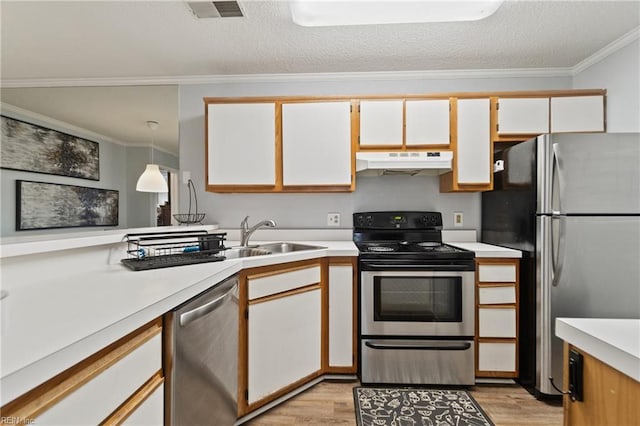 kitchen featuring under cabinet range hood, stainless steel appliances, visible vents, light countertops, and light wood-type flooring