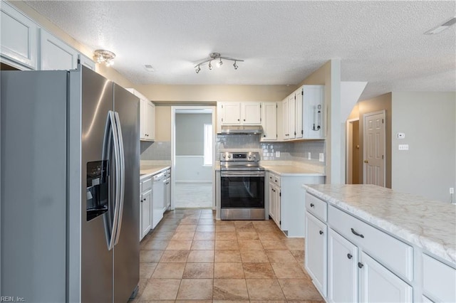 kitchen featuring under cabinet range hood, tasteful backsplash, appliances with stainless steel finishes, and light countertops