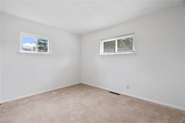 unfurnished room with visible vents, baseboards, and carpet floors