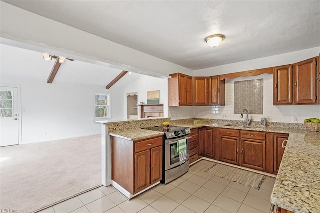 kitchen featuring stainless steel electric range oven, a peninsula, a sink, light colored carpet, and brown cabinets