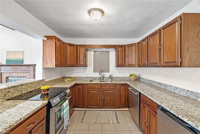 kitchen featuring a sink, tasteful backsplash, brown cabinets, and stainless steel appliances