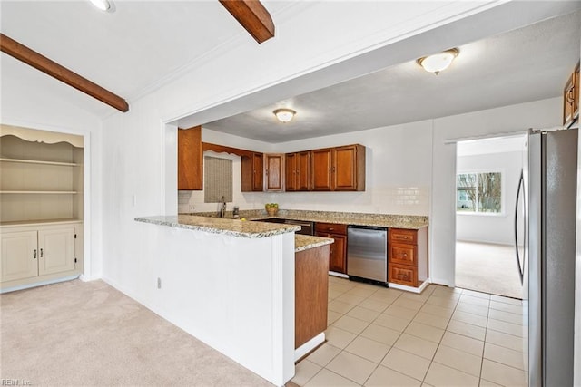 kitchen with light stone countertops, a peninsula, stainless steel appliances, light carpet, and brown cabinets