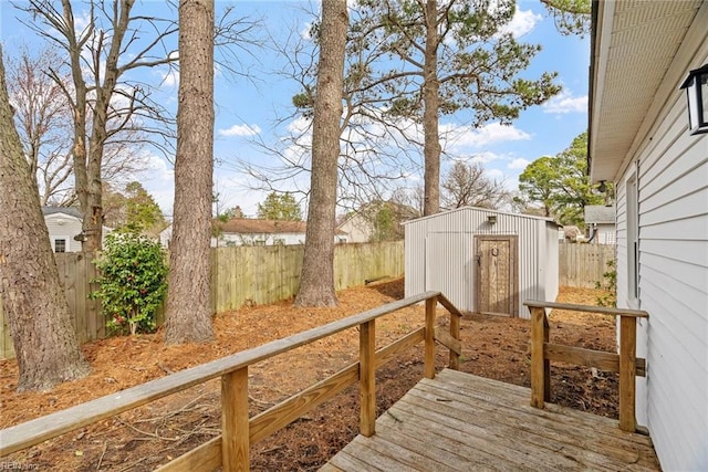 deck with an outdoor structure, a fenced backyard, and a shed