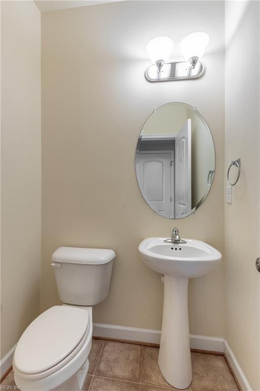 bathroom with toilet, tile patterned flooring, and baseboards