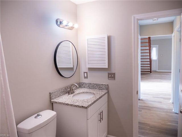 bathroom featuring vanity, toilet, and wood finished floors