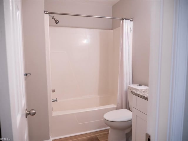 bathroom featuring shower / bath combination with curtain, vanity, toilet, and wood finished floors