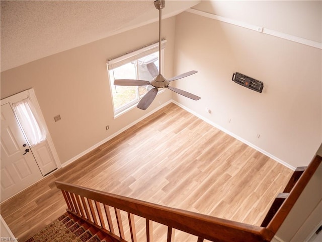 foyer with ceiling fan, a textured ceiling, lofted ceiling, wood finished floors, and baseboards