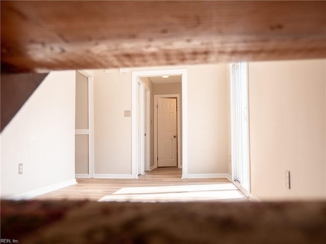 bonus room featuring light wood-style floors and baseboards